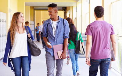 Small high school students walking down hallway talking feature image